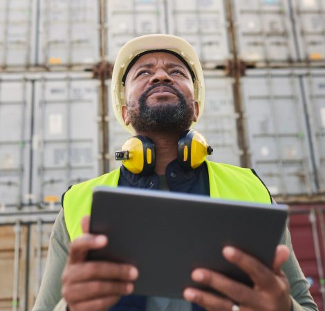 Logistics, tablet and black man doing container inspection at an industrial cargo, shipping and fre
